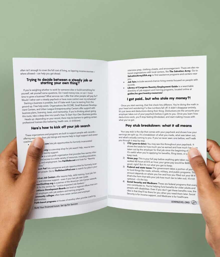 Hands holding an opened printed version of Level's prison education guide Build Your Financial Future: Set Up For Success